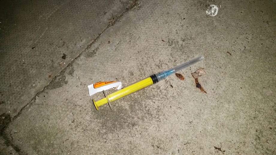A hypodermic carelessly discarded by a drug addict. A hypodermic carelessly discarded by a drug addict.